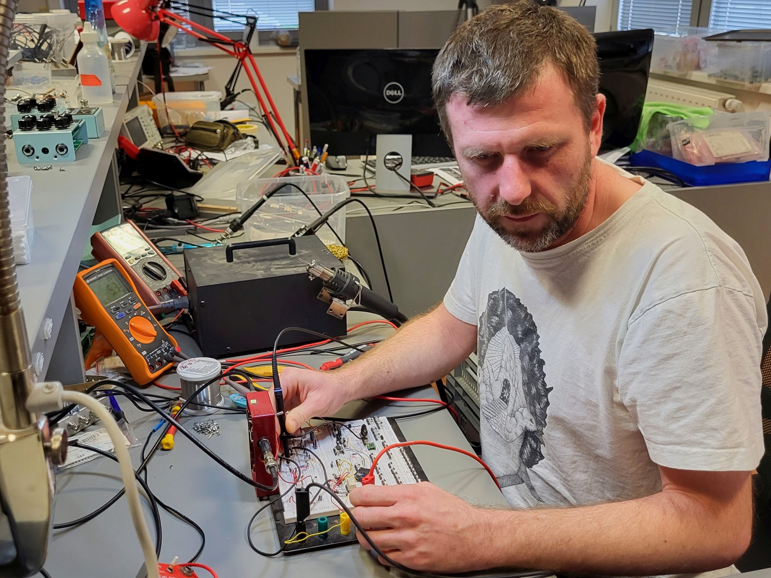 Zvonch, owner of DryBell, working at the electronic workbench with a breadboard.