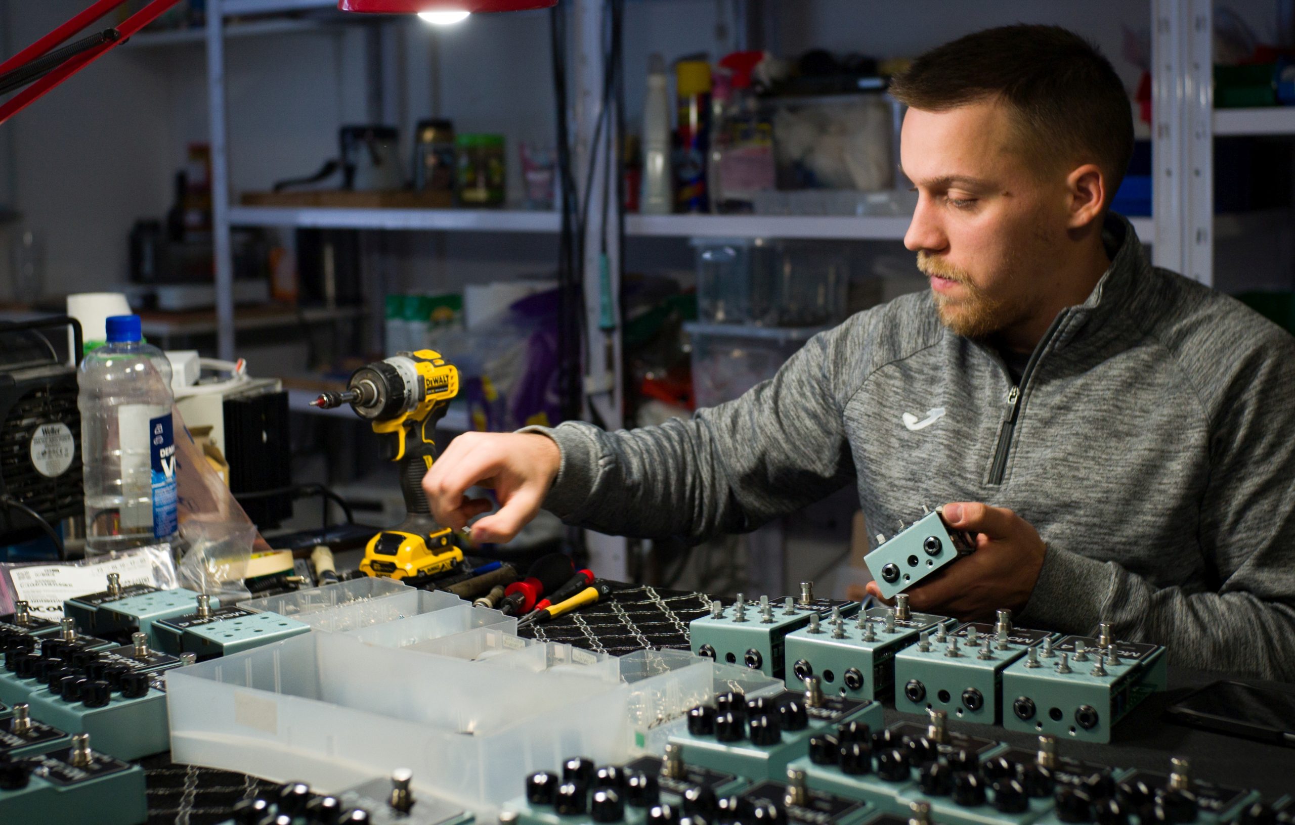 Luka assembling DryBell Module 4 compressors at a table filled with pedals and tools.