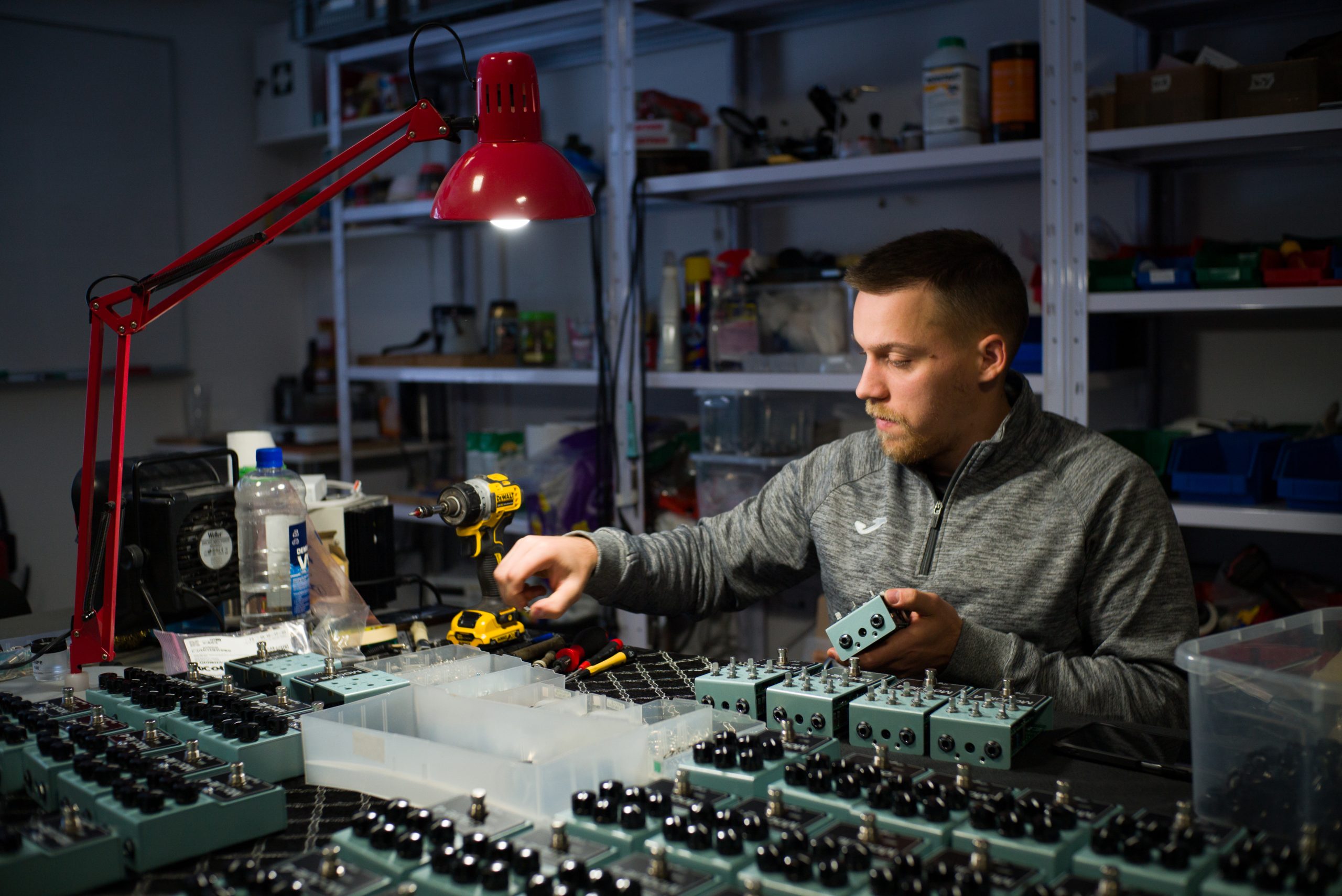 Luka assembling DryBell Module 4 compressors at a table filled with pedals and tools.