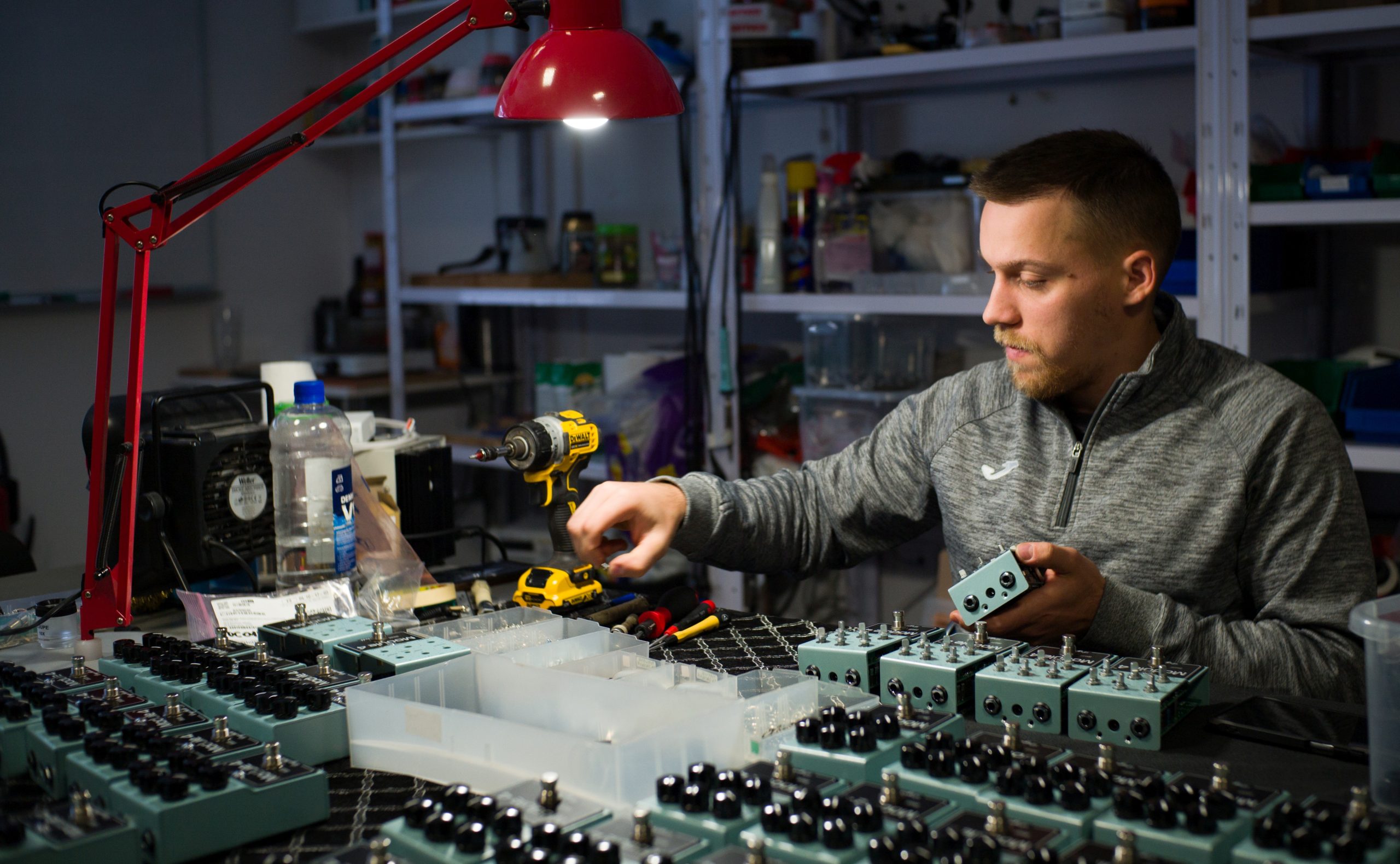 Luka assembling DryBell Module 4 compressors at a table filled with pedals and tools.