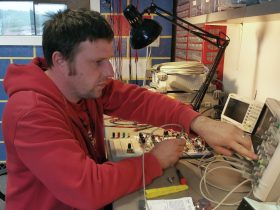 Zvonko Suhodolcan, owner of DryBell, analyzes a breadboard circuit with an oscilloscope during pedal development.